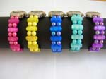 Circle clock face with assorted color round and long oval shape beads forming in bangle watch