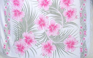 pink hibiscus flower green palm leaf Indonesian sarong on white background